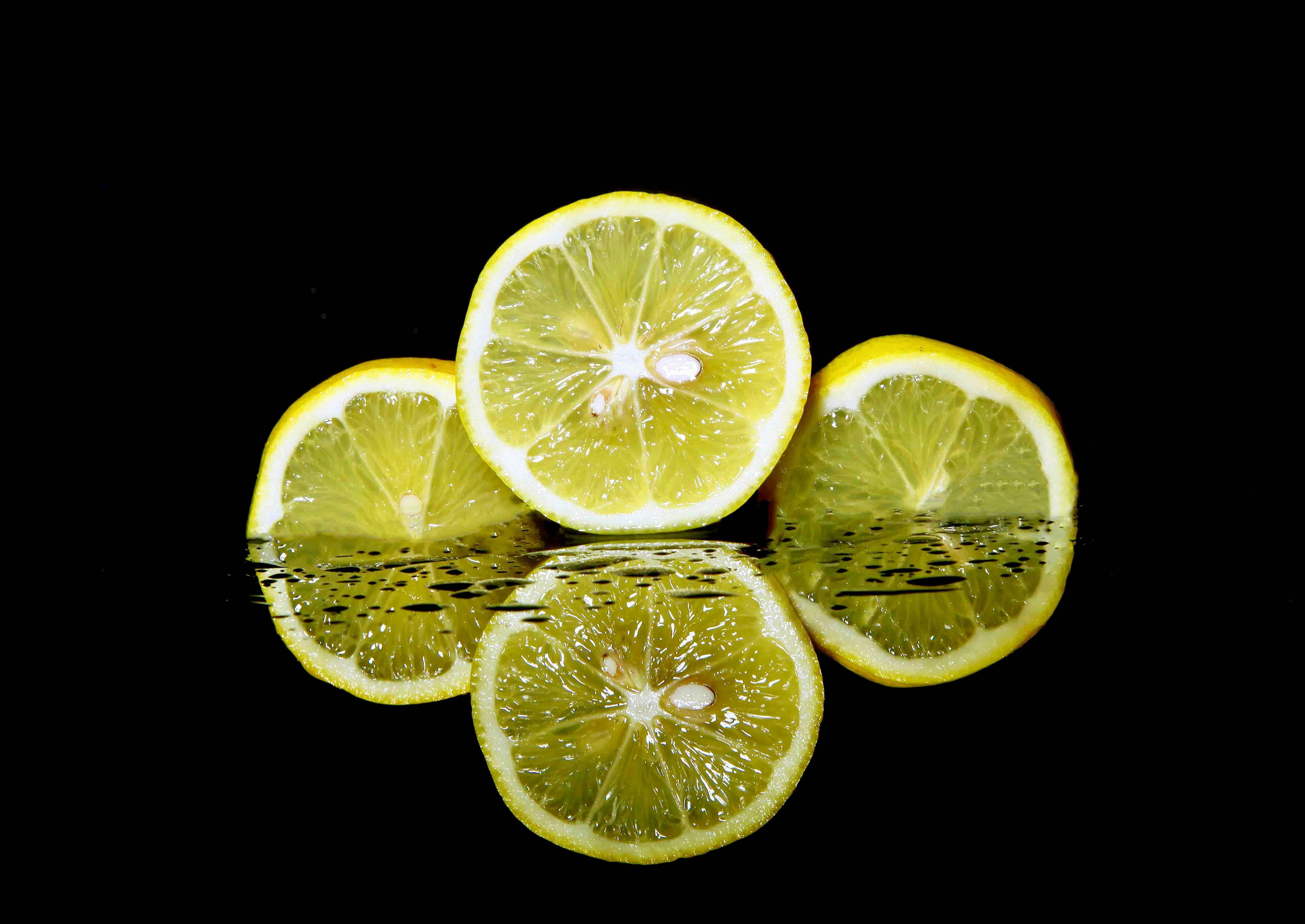 Fresh lemon slices with water reflections